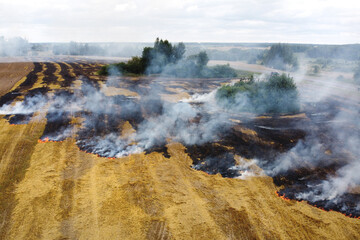 Aerial view of burning field with smoke