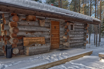 Fototapeta na wymiar log cabin in a pine forest in winter