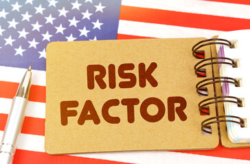 On the US flag lies a notebook with the inscription - RISK FACTOR