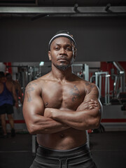 Fototapeta na wymiar Muscular athletic african american guy with naked torso posing on training in gym. Sportive lifestyle and exercising