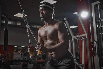 Fototapeta na wymiar Sporty african american man exercising in gym. Active strength training. Sport and healthy lifestyle