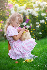 blonde girl collects fruit pears in a basket, summer day