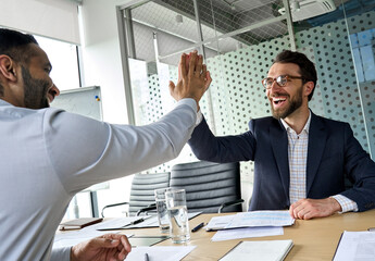 Two happy multiethnic professional businessmen executive ceo leaders partners giving highfive after...