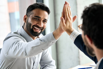 Indian happy smiling multiracial professional ceo businessman giving highfive to business partner...