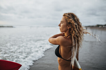 Girl with wavy blond hair looks at sea © Look!