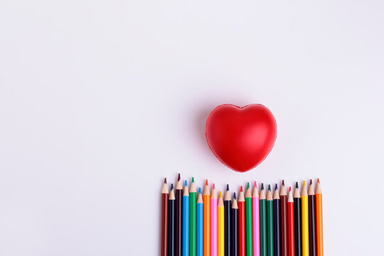 Decorative squishy heart  and  coloor pencils for baby development on white background.