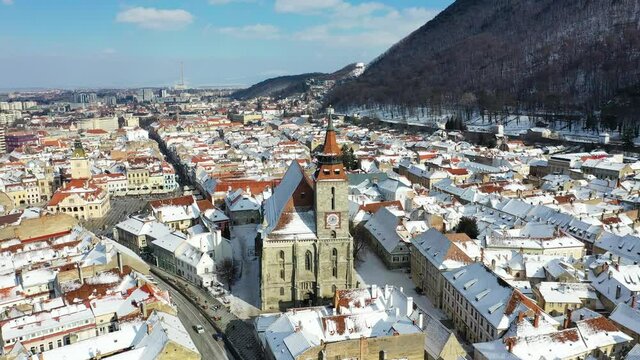 Drone flying over Brasov, Romania - Black Church and downtown, winter travel landmark in Carpathian Mountains, Transylvania.