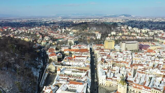 Drone flying over Brasov, Romania - Black Church and downtown, winter travel landmark in Carpathian Mountains, Transylvania.