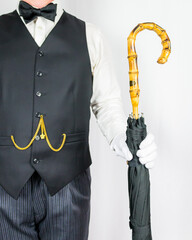Portrait of Butler or Servant in Black Vest and White Gloves Offering Umbrella on White Background....