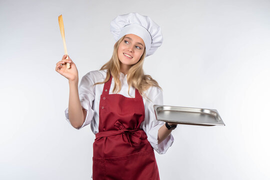Portrait of chief in working uniform. empty tray in hands of chef. cook in red apron. girl cook smiles. blonde-haired woman is cook. Restaurant chef on white background. Place for dish on tray