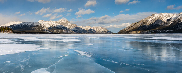 Frozen winter lake rocky mountain panoramic landscape. Blue ice winter Canadian landscapes panorama background
