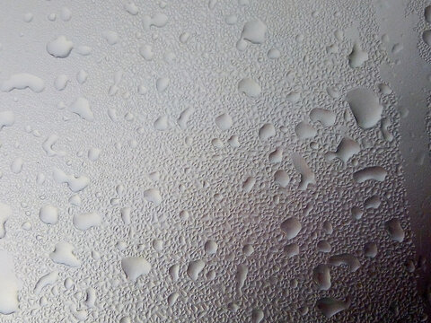 dew drops on gray car roof as an abstract background