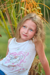 Portrait of a baby girl on a background of dates. A child near the date palm