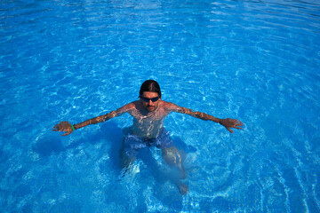man in the pool wearing sunglasses