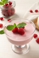 Delicious raspberry mousse with mint on white wooden table