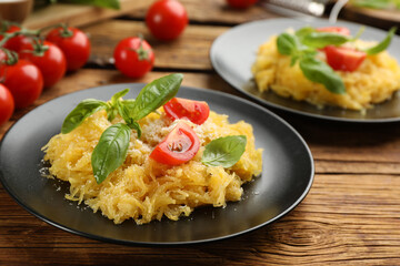 Tasty spaghetti squash with tomatoes and basil served on wooden table