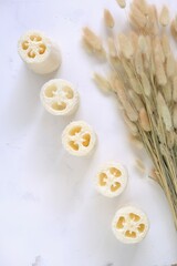 Loofah sponge set and dried flowers on a light shabby background.Eco-friendly natural hygiene and...