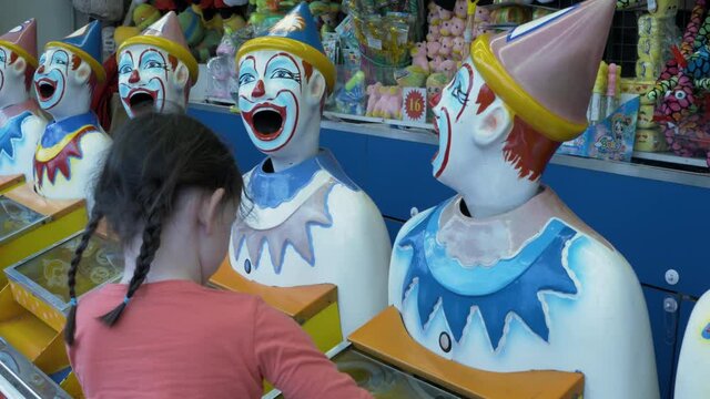 little child girl playing carnival amusement laughing rotating clowns