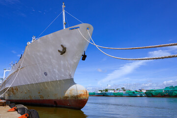 Low angle view of oil tanker moored at harbor against blue sky background