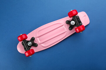 Pink skateboard on blue background, top view © New Africa
