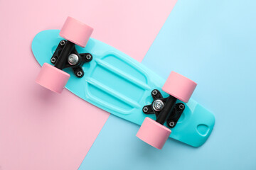 Turquoise skateboard on color background, top view