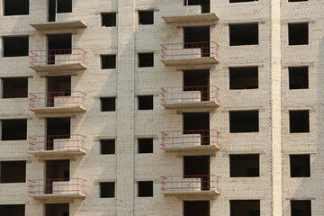 Unfinished white brick multistory building as background