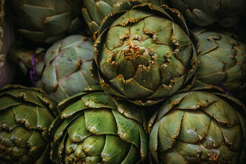 Raw vegetables artichokes . Closeup selective focus. Dark toning.