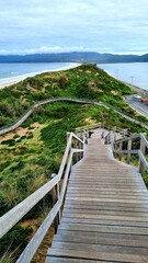 View from the lookout at The Neck Bruny Island over the beach with cloudy skies. Tasmania Australia. Showing the Steps up to the viewing platform