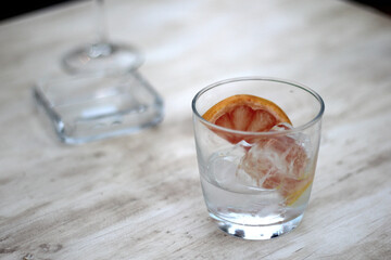Classic Gin drink cocktail shaked with grapefruit in elegant glasses next to colorful flowers on an elegant table
