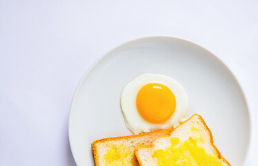 ไข่ดาวบนจานบนพื้นหลังสีขาว มุมมองด้านบนแบบโคลสอัพ