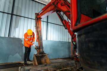 A technician working Small Excavator Repair and Maintenance. Caucasian Heavy Equipment Mechanic Trying to Find an Issue. Industrial Theme.