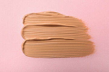 Sample of liquid skin foundation on pink background, top view