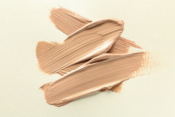 Sample of liquid skin foundation on beige background, top view