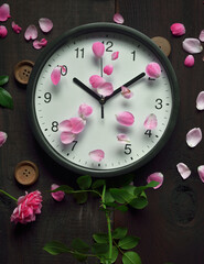 classic clock and rose on wooden background