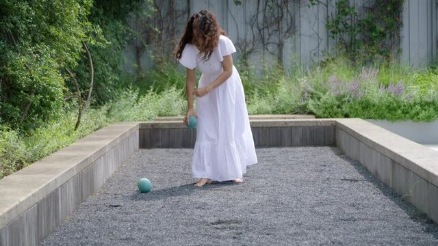 Woman plays bocce ball.