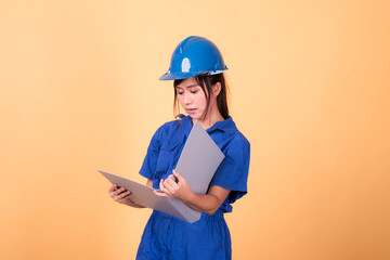 Young Asian female engineer working deliberately isolated on yellow background.	