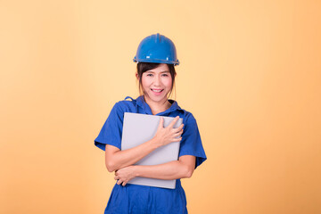 Young Asian female engineer working deliberately isolated on yellow background.	