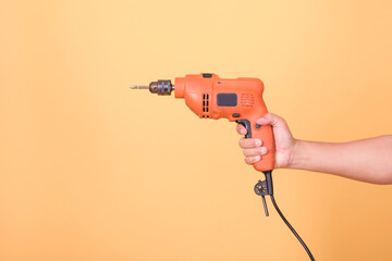 Senior male engineers or carpenters use electrical equipment to polish old woodwork. Carpentry and craftsmanship concept Isolated on yellow background