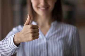 Crop close up of smiling woman show thumb up give recommendation to good quality customer service. Happy satisfied female client make hand gesture sign recommend best experience. Success concept.