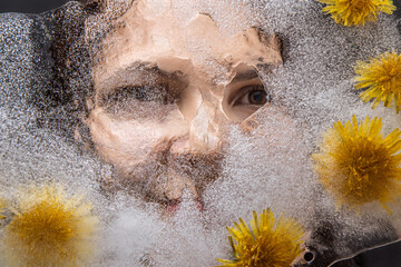 woman eyes  through transparent ice with dandelions flowers 