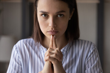 Fototapeta na wymiar Portrait of determined serious young Caucasian businesswoman look at camera thinking making decision. Concentrated millennial woman leader make hand gesture pondering or planning. Leadership concept.