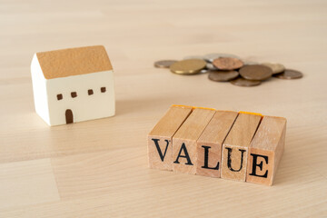 住宅の資産価値｜「VALUE」と書かれたスタンプと家のおもちゃとお金