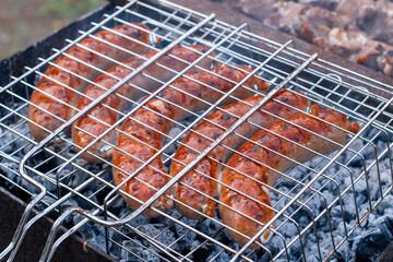 pork sausages fried on coals on the grill