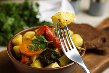 Tasty cooked dish with potatoes in earthenware, closeup