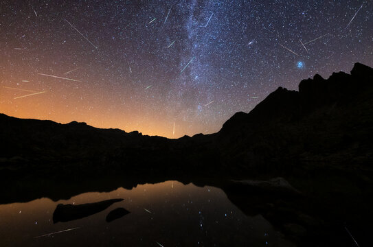 Perseidas meteoros sobre un lago reflejo y v&iacute;a l&aacute;ctea