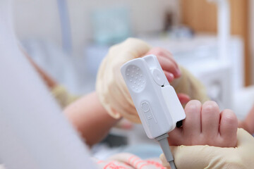 Measuring the oxygen level in the blood of a child. Pulse oximeter on a child's finger. Preparing for surgery. Out of focus. Close-up - obrazy, fototapety, plakaty