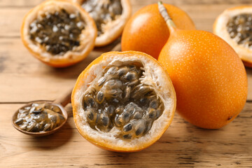 Delicious ripe granadillas on wooden table, closeup