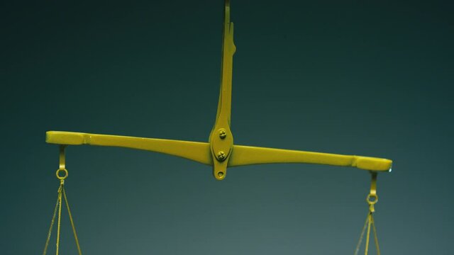Yellow jewelry retro weigher . The scales are unsteady until they balance . Symbol of justice . Weights on the scales . Studio shot on RED EPIC Cinema Camera with strobe light .
