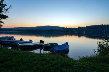 Coucher de soleil sur le lac de Paladru en france en Isère en été avec des bateaux en premier...