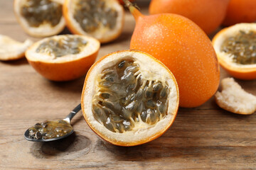Delicious ripe granadillas on wooden table, closeup